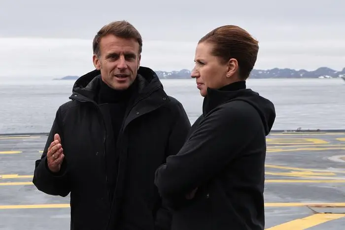 (FILES) French President Emmanuel Macron (L) talks with Denmark's Prime Minister Mette Frederiksen aboard the Danish frigate F363 Niels Juel in Nuuk, Greenland, on June 15, 2025. Greenland 